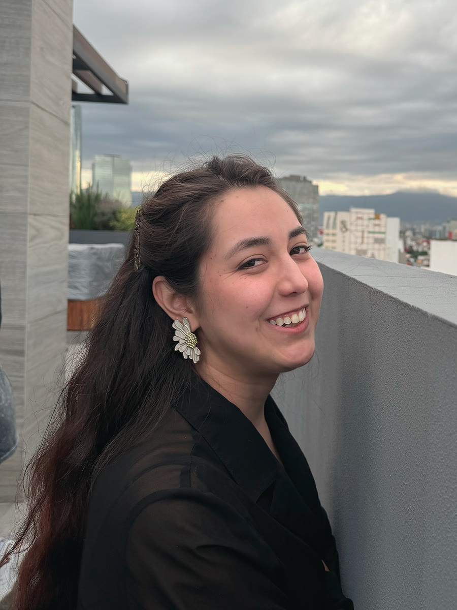 Lluvia Bruja sonriendo, con un arete de flor